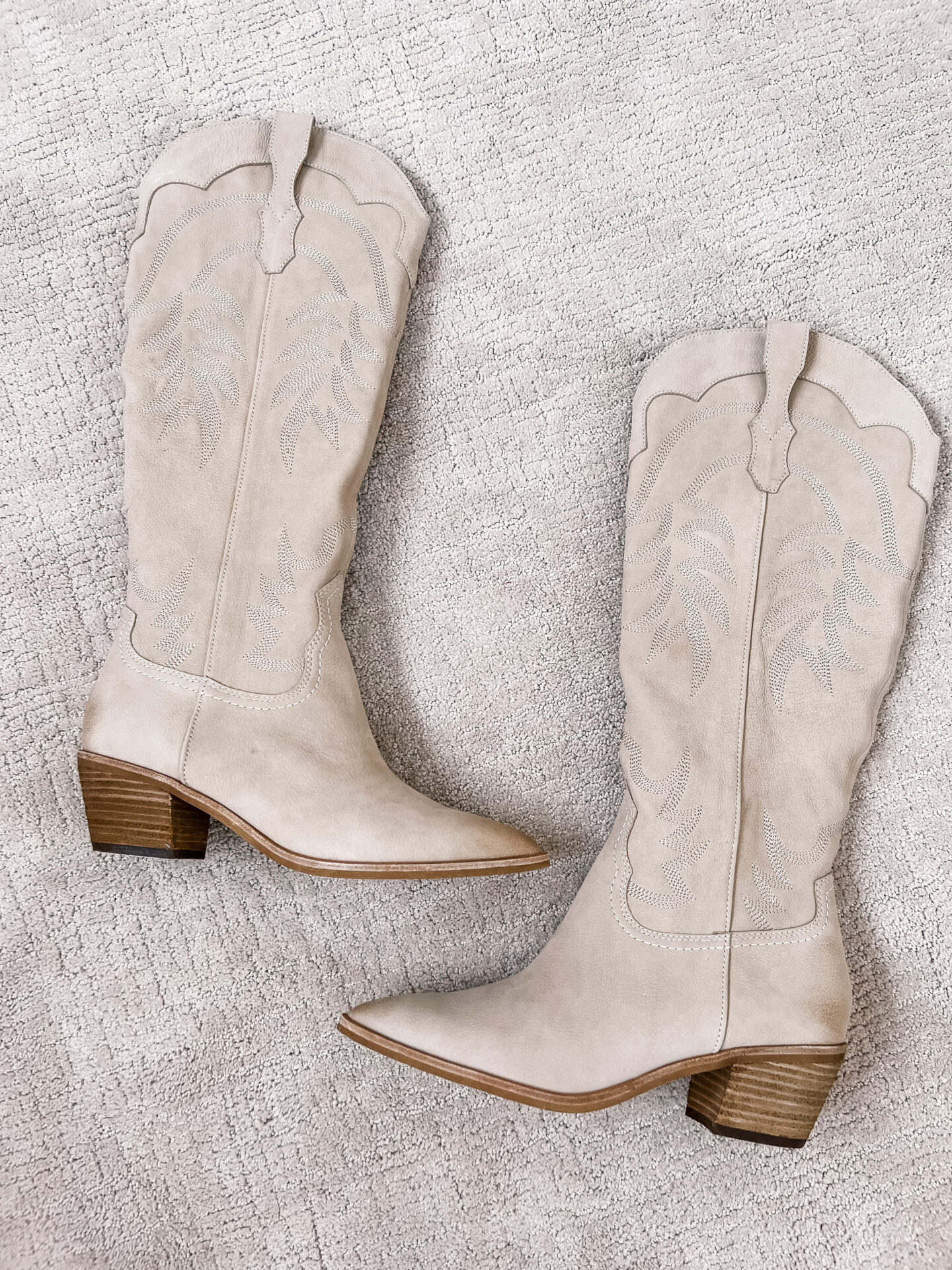 cowboy boots laying on carpet