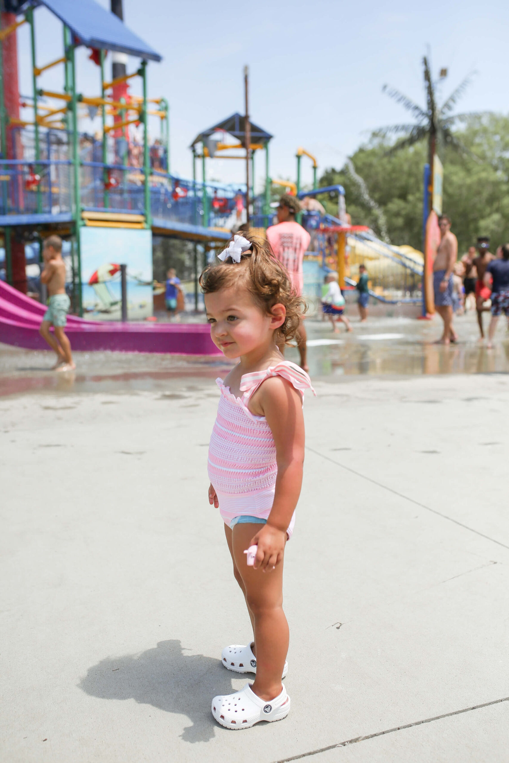 little girl at waterpark with pink and white swimsuit