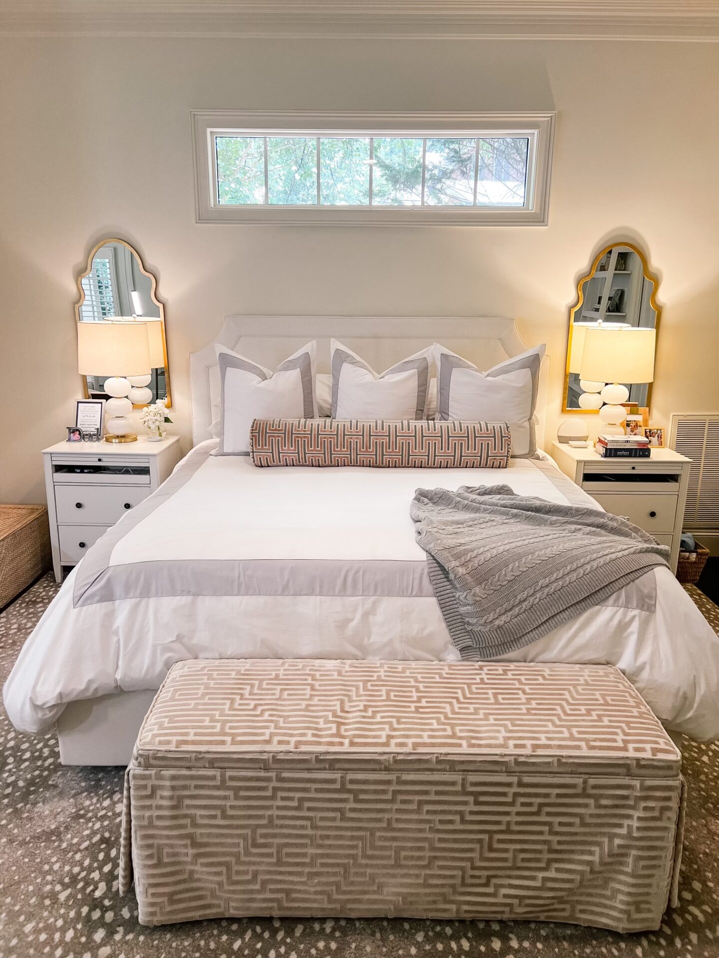 primary bedroom with white bedding and upholstered bed