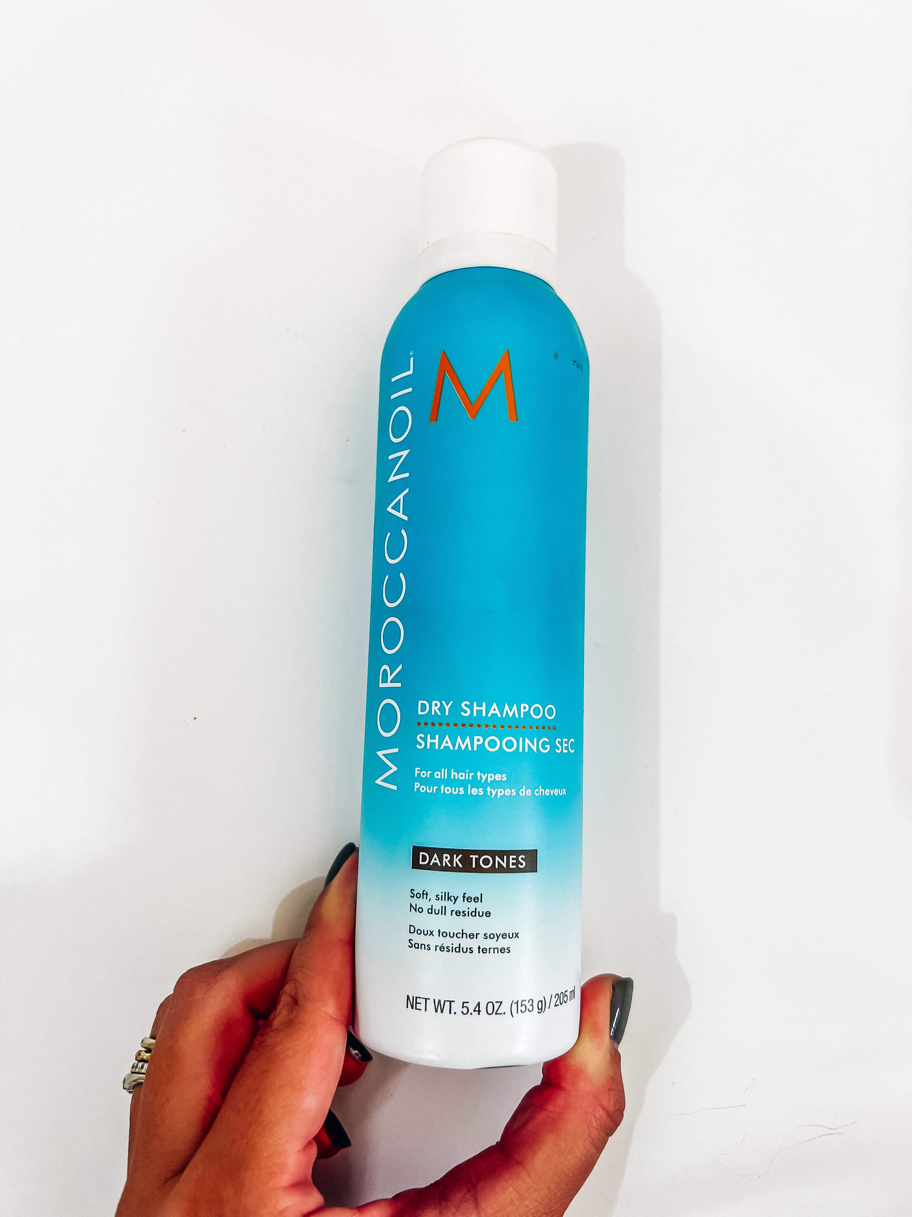 woman's hand holding can of moroccan oil dry shampoo