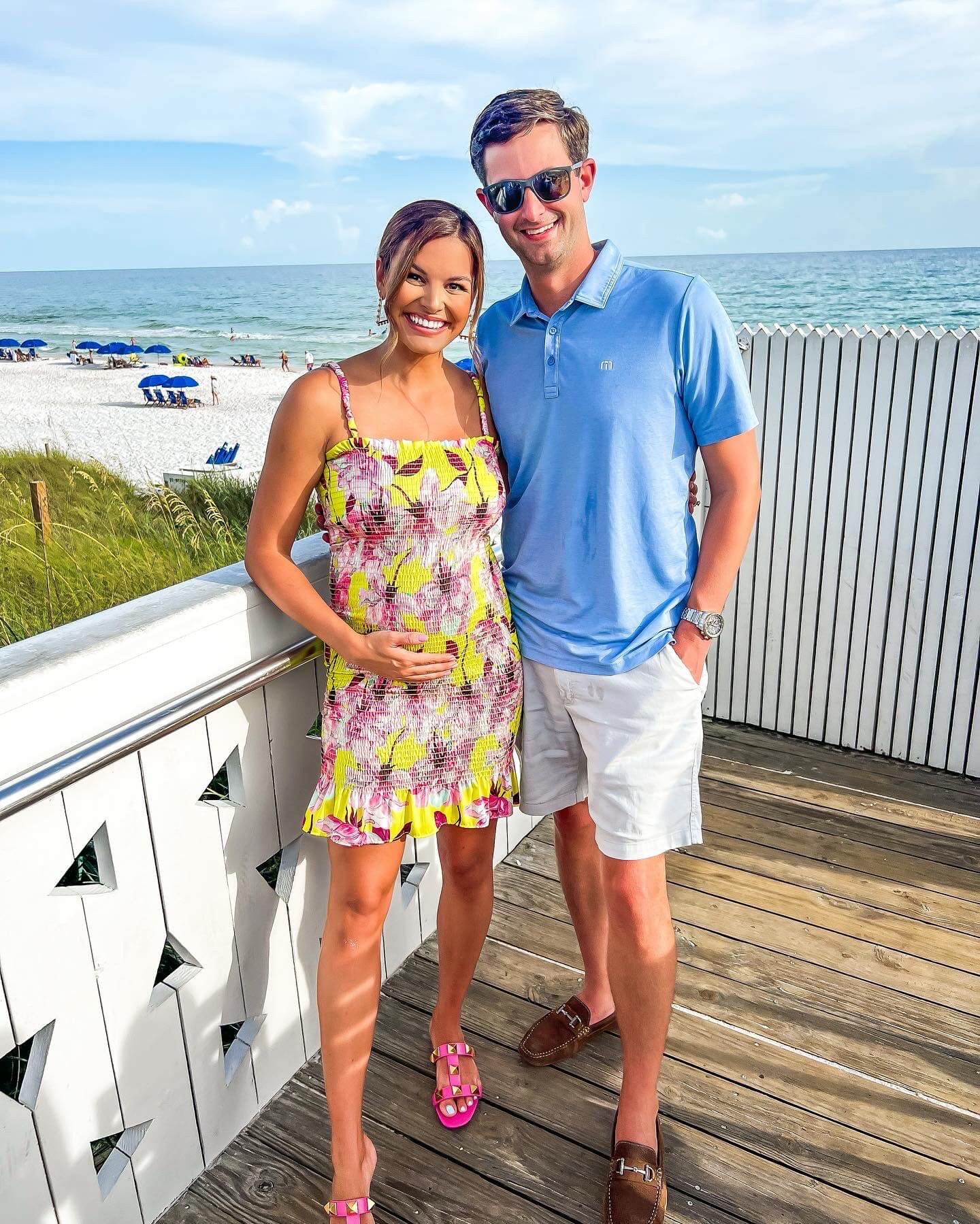 woman in yellow smocked dress standing next to man in blue shirt