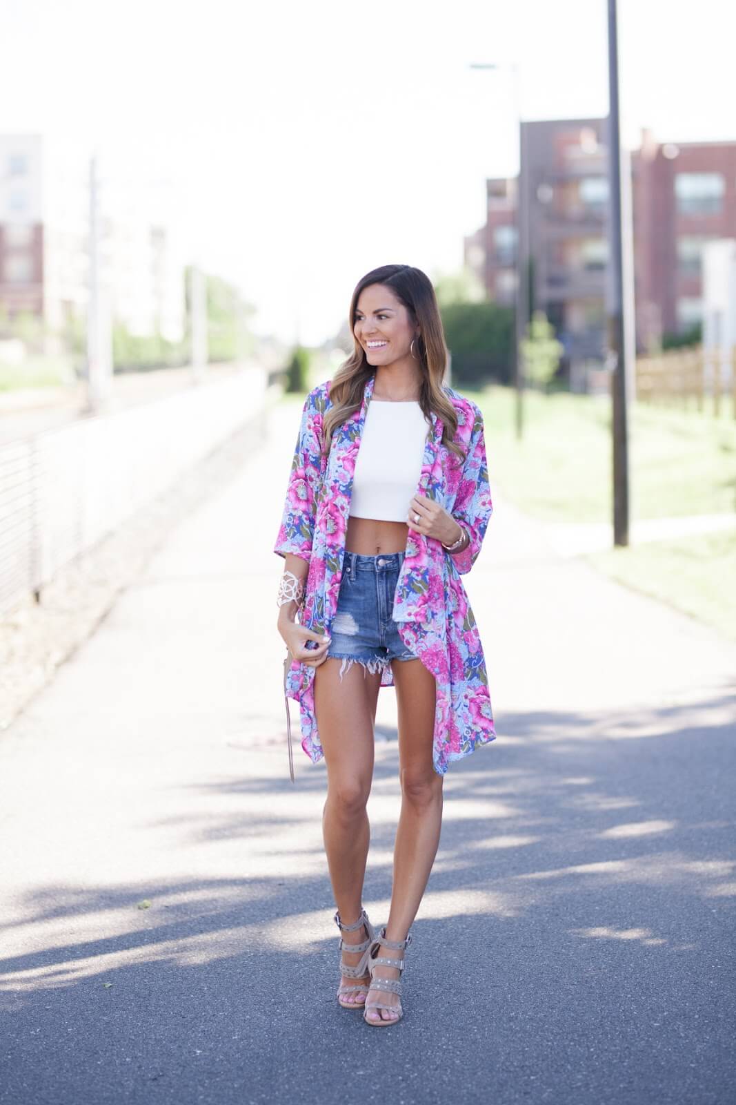 woman with white crop top and kimono wearing denim shorts