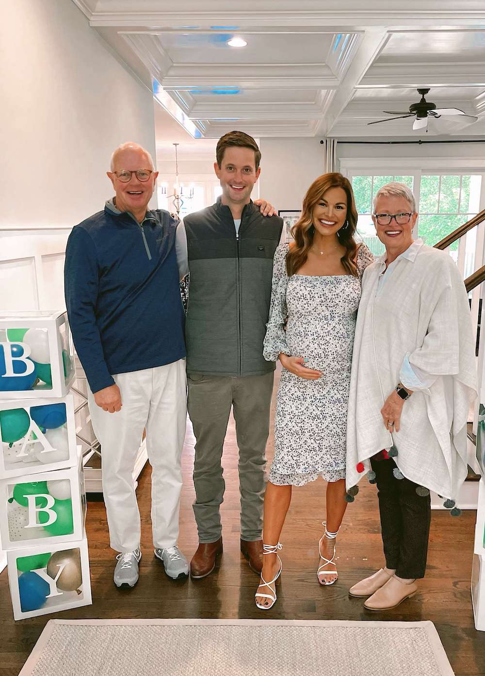 pregnant couple standing with parents at baby sprinkle