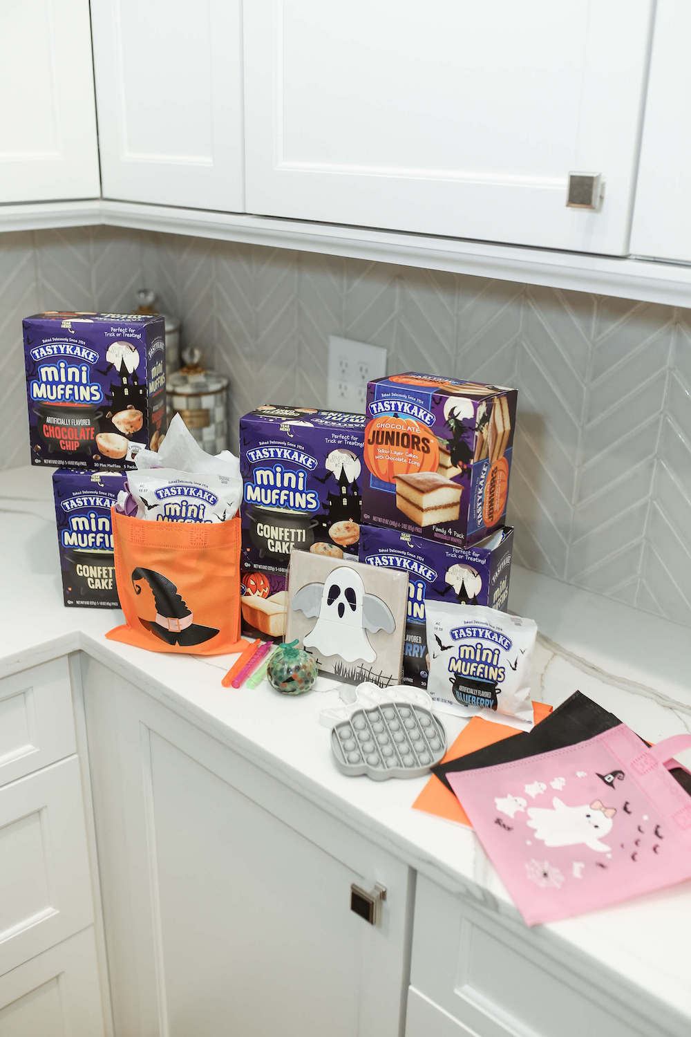 tastykake and gray popit toys sitting on counter to put in boo bags