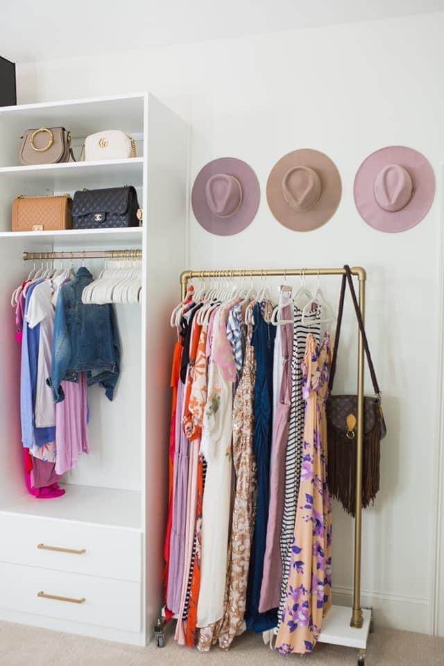 small bedroom converted to a walk in closet with 3 hats hanging on the wall