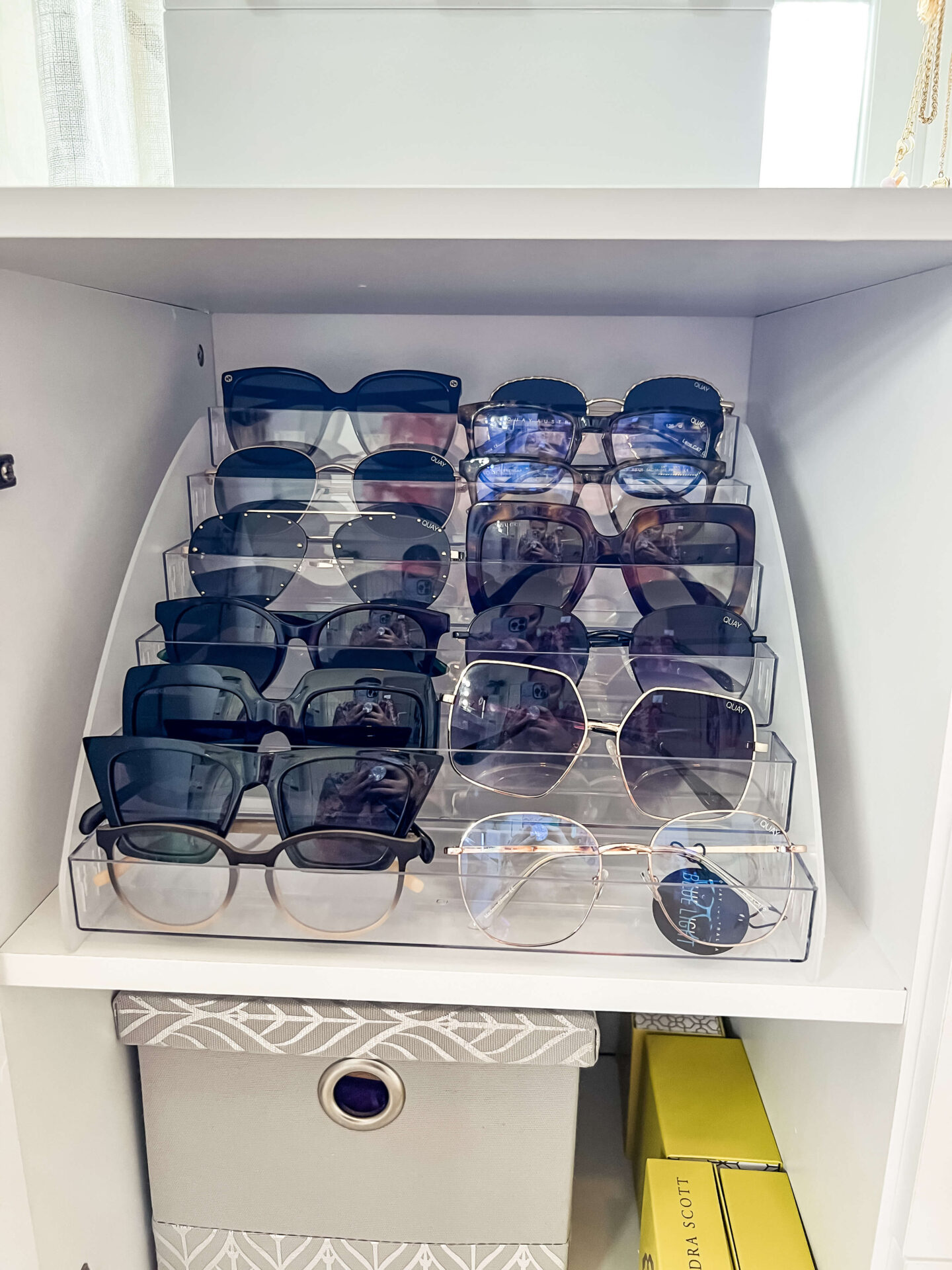 clear acrylic tray with sunglasses on white shelf in closet