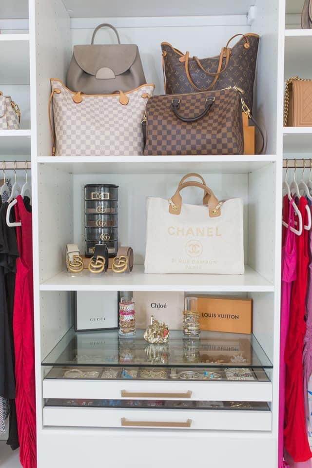 purses and handbags sitting on shelf in closet