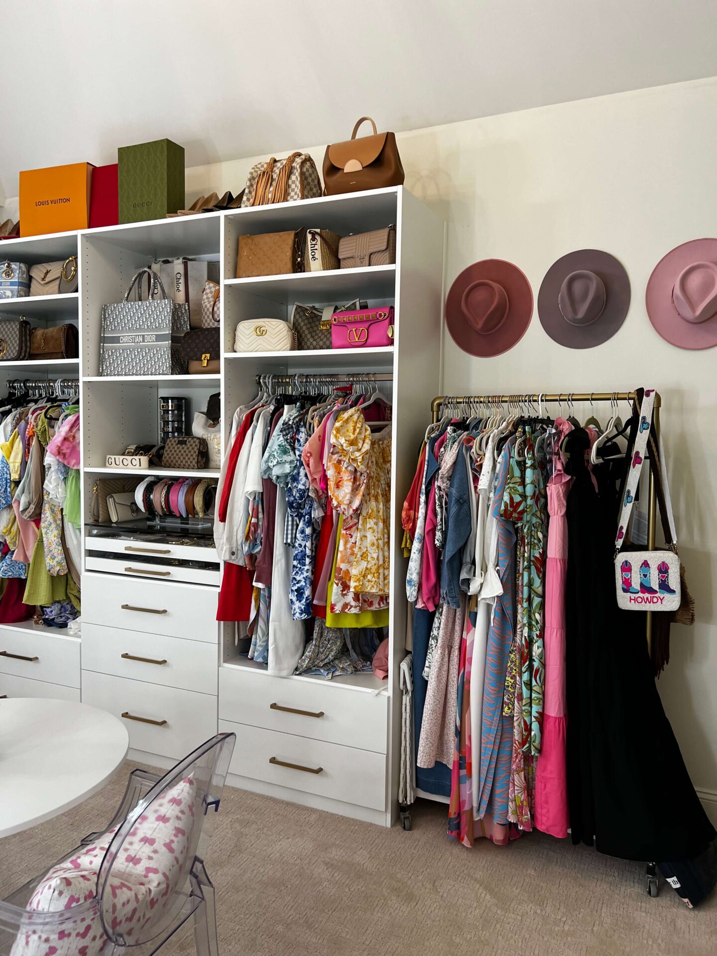 closet room with purses and clothes in white built in shelving units