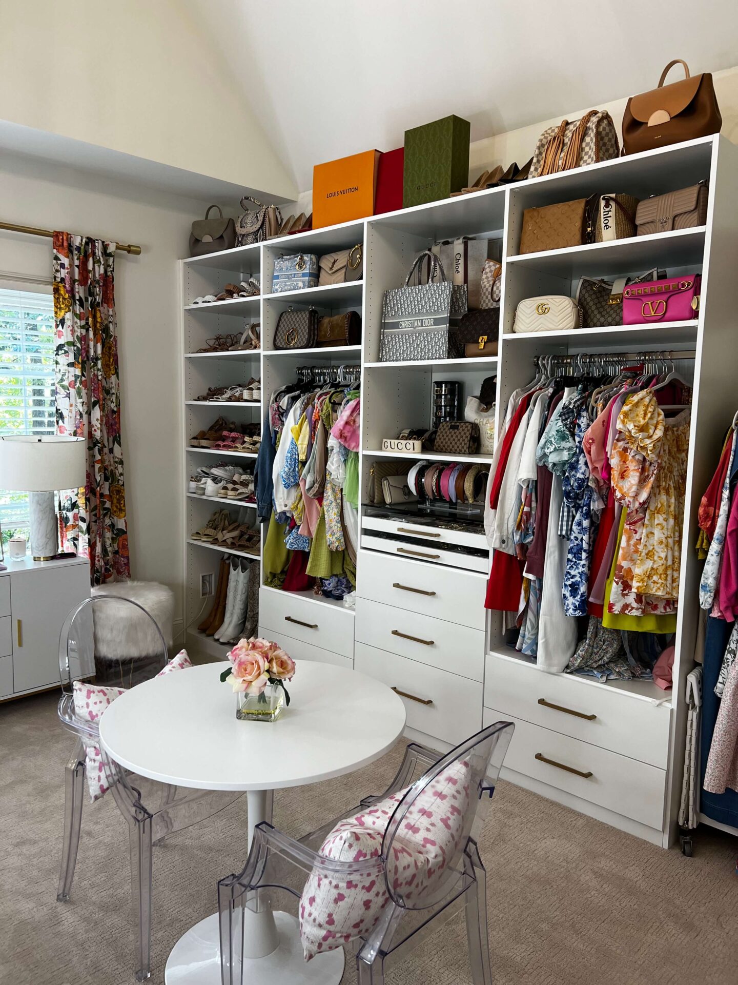 closet room with purses and clothes in white built in shelving units