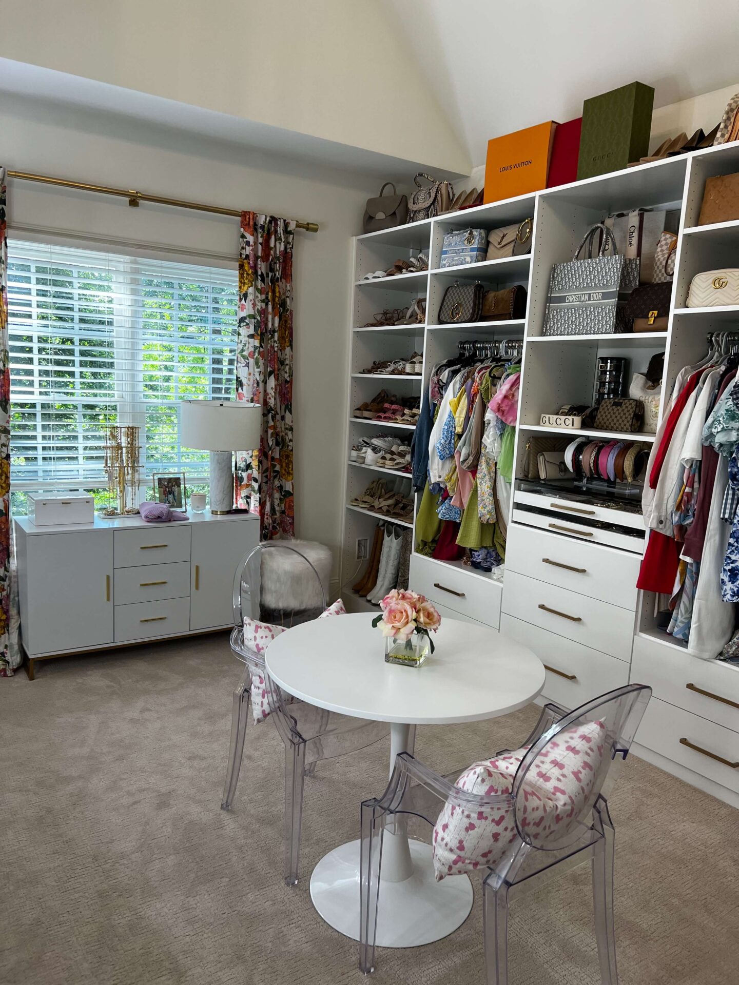 closet room with purses and clothes in white built in shelving units