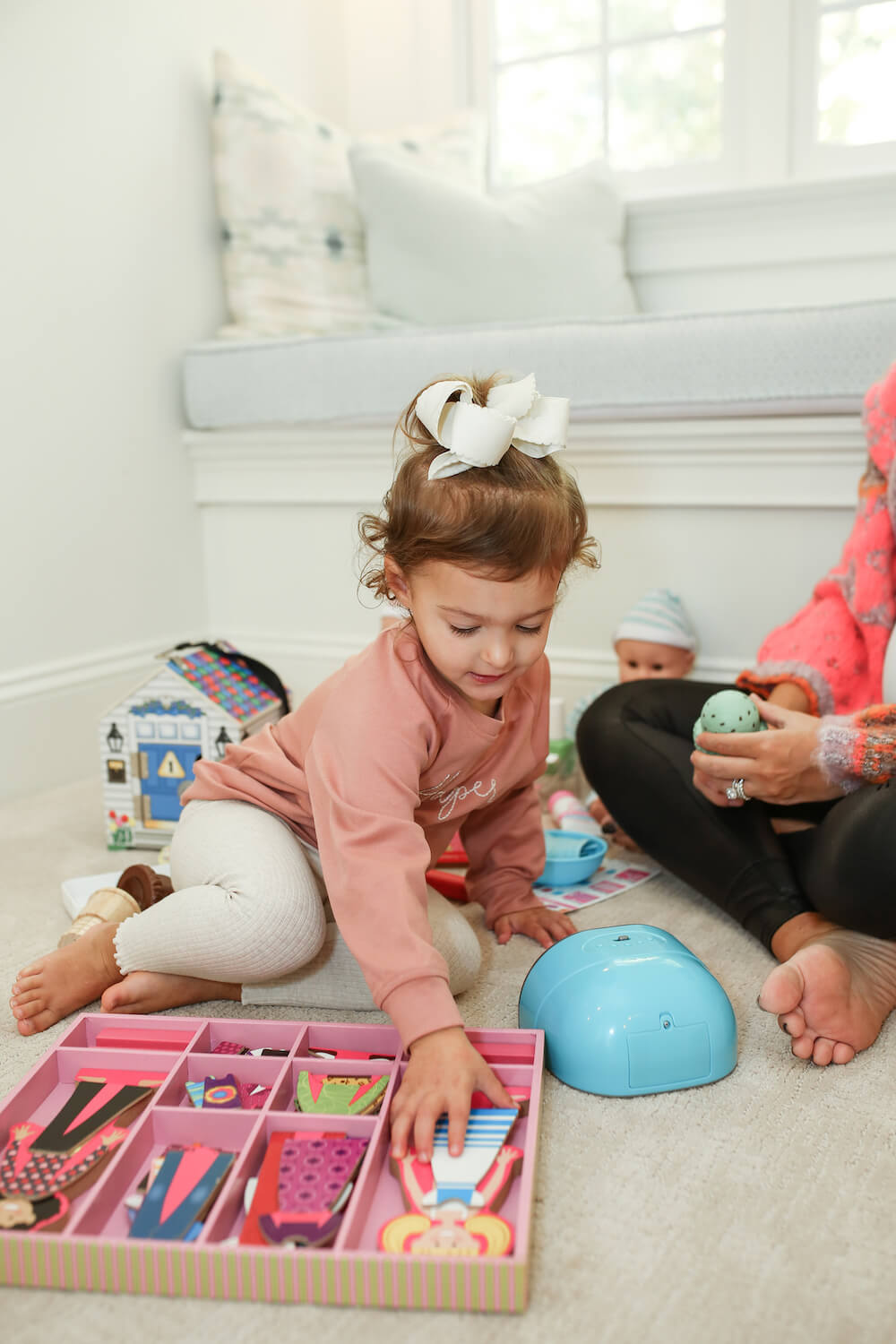 little girl playing with melissa and doug toys on the floor