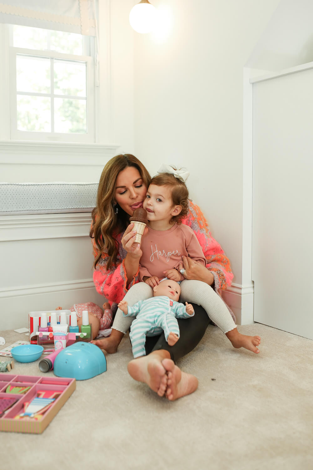 mom licking fake ice cream from melissa and doug with little girl sitting in her lap