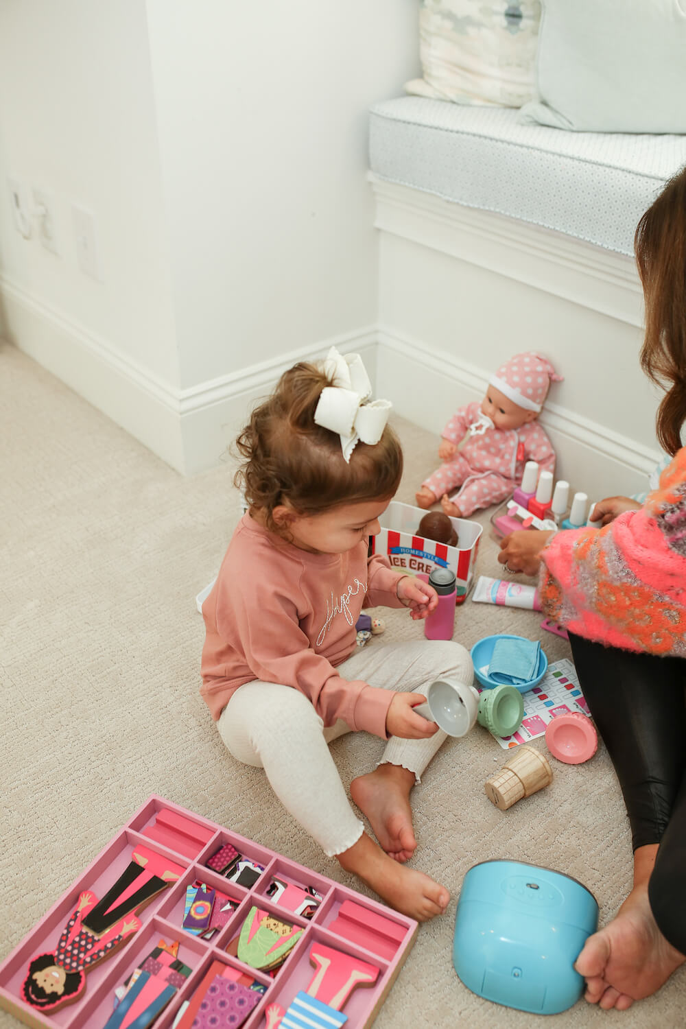 little girl playing with melissa and doug toys on the floor