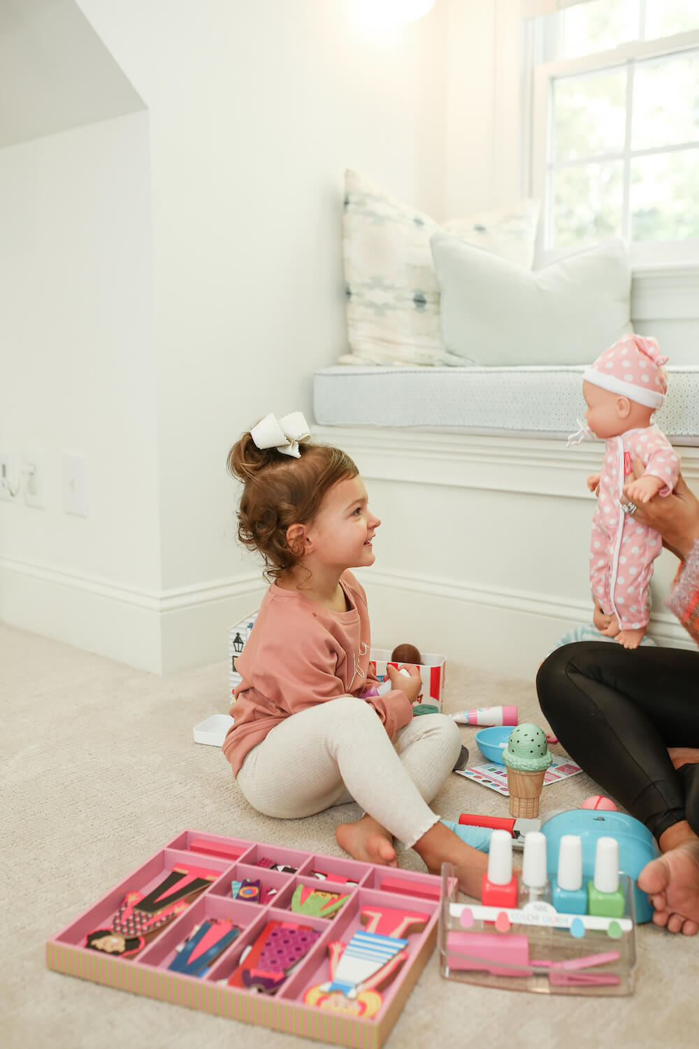 little girl playing with melissa and doug toys on the floor