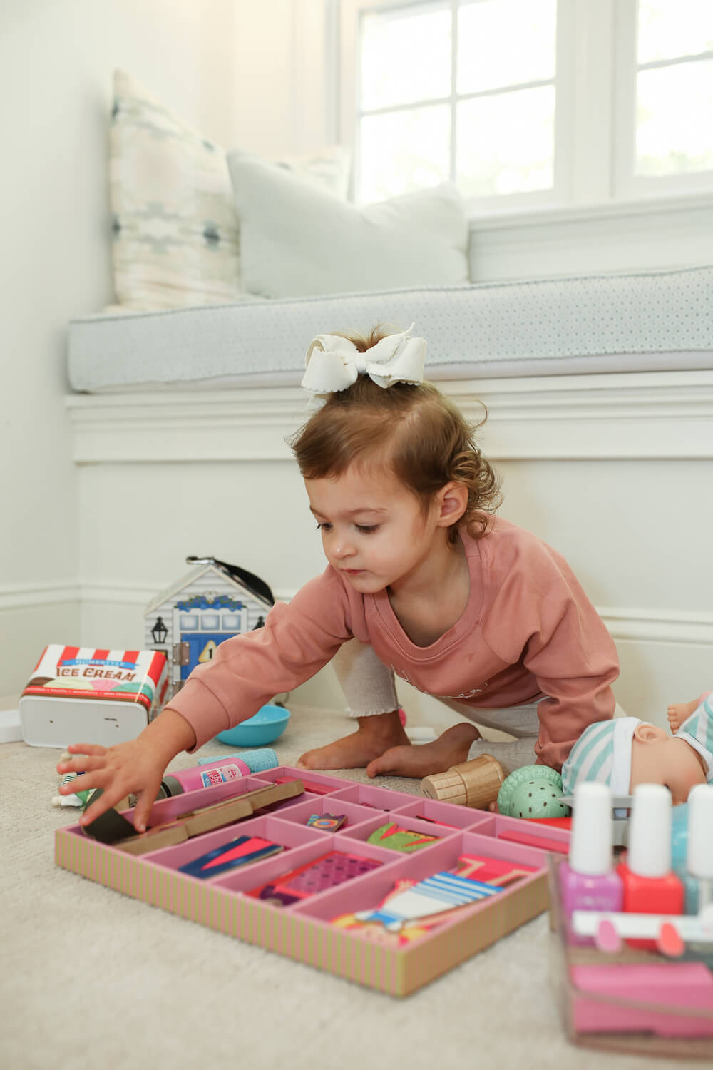 little girl playing with melissa and doug toys on the floor