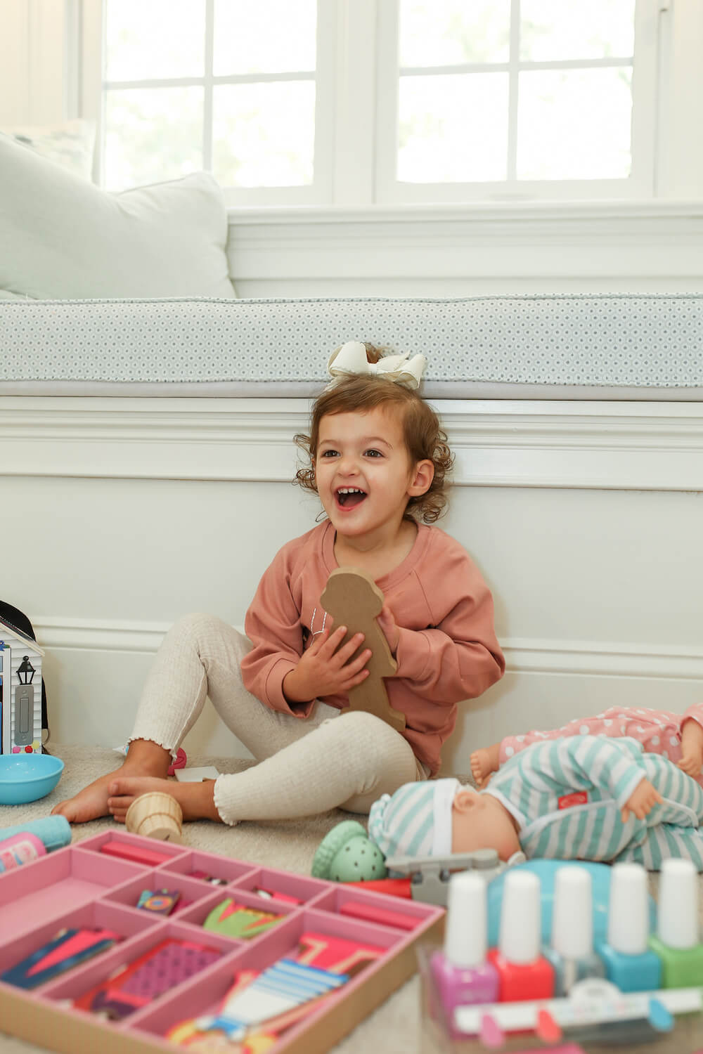 little girl playing with melissa and doug toys on the floor