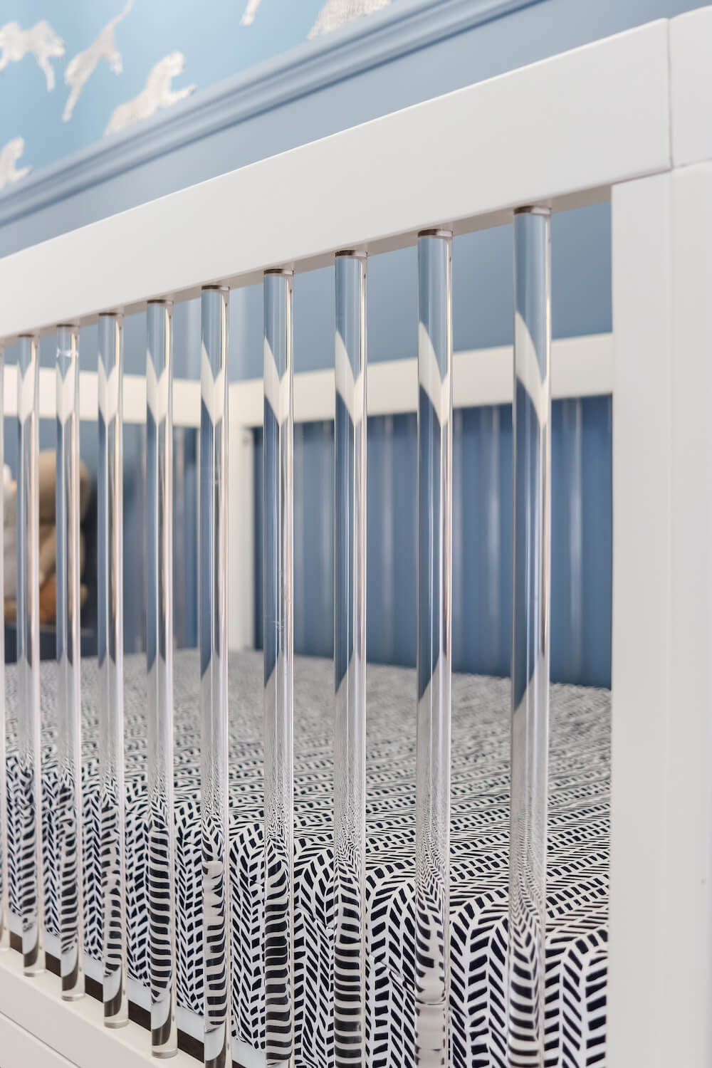 closeup of white crib with acrylic bars