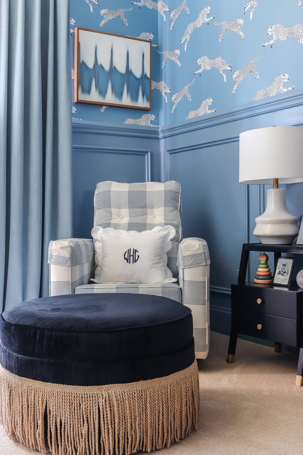 navy ottoman in front of blue and white gingham nursery glider