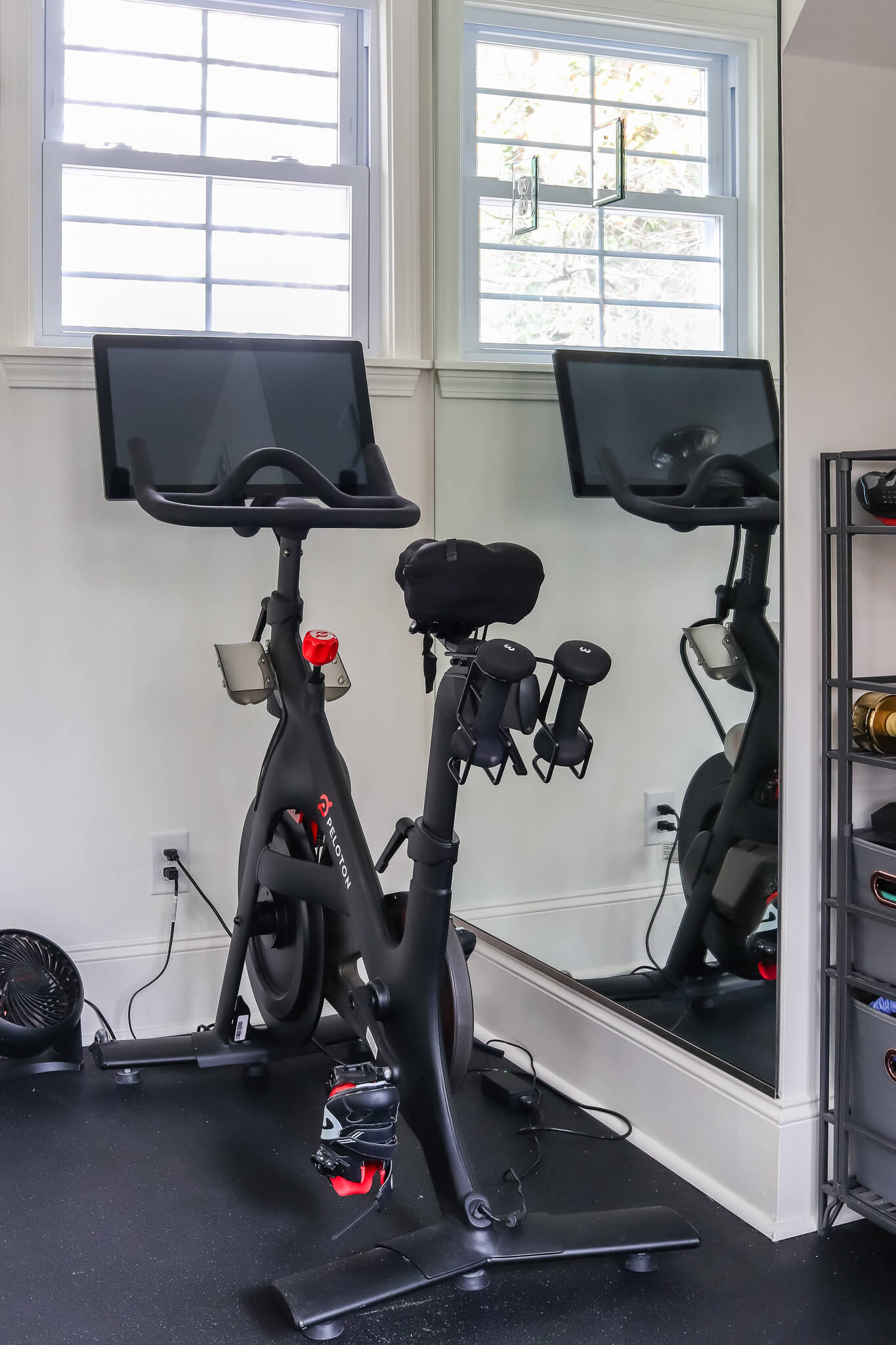 peloton bike in front of mirrors in home gym