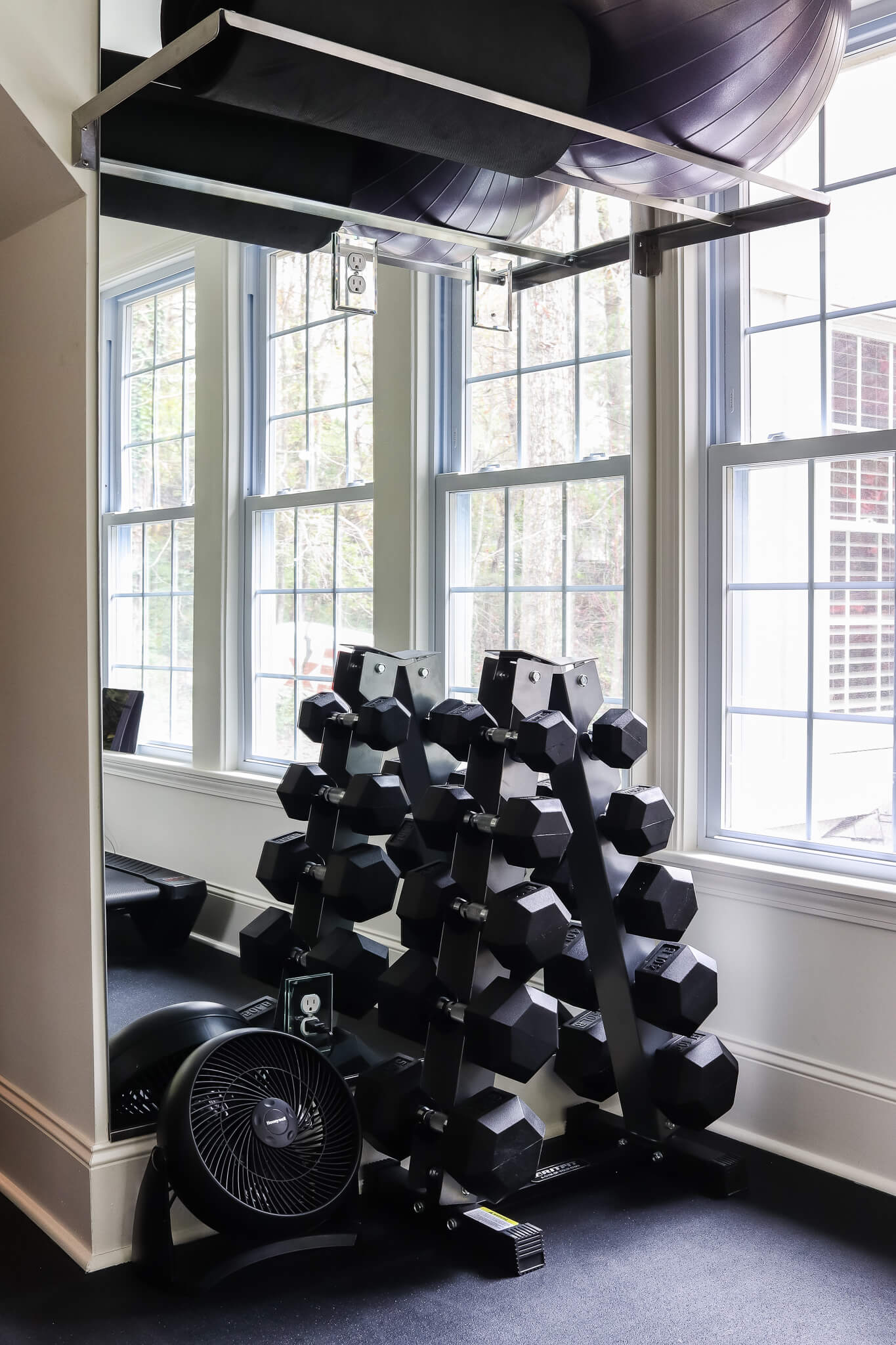 barbell weight rack in home gym in front of mirrors