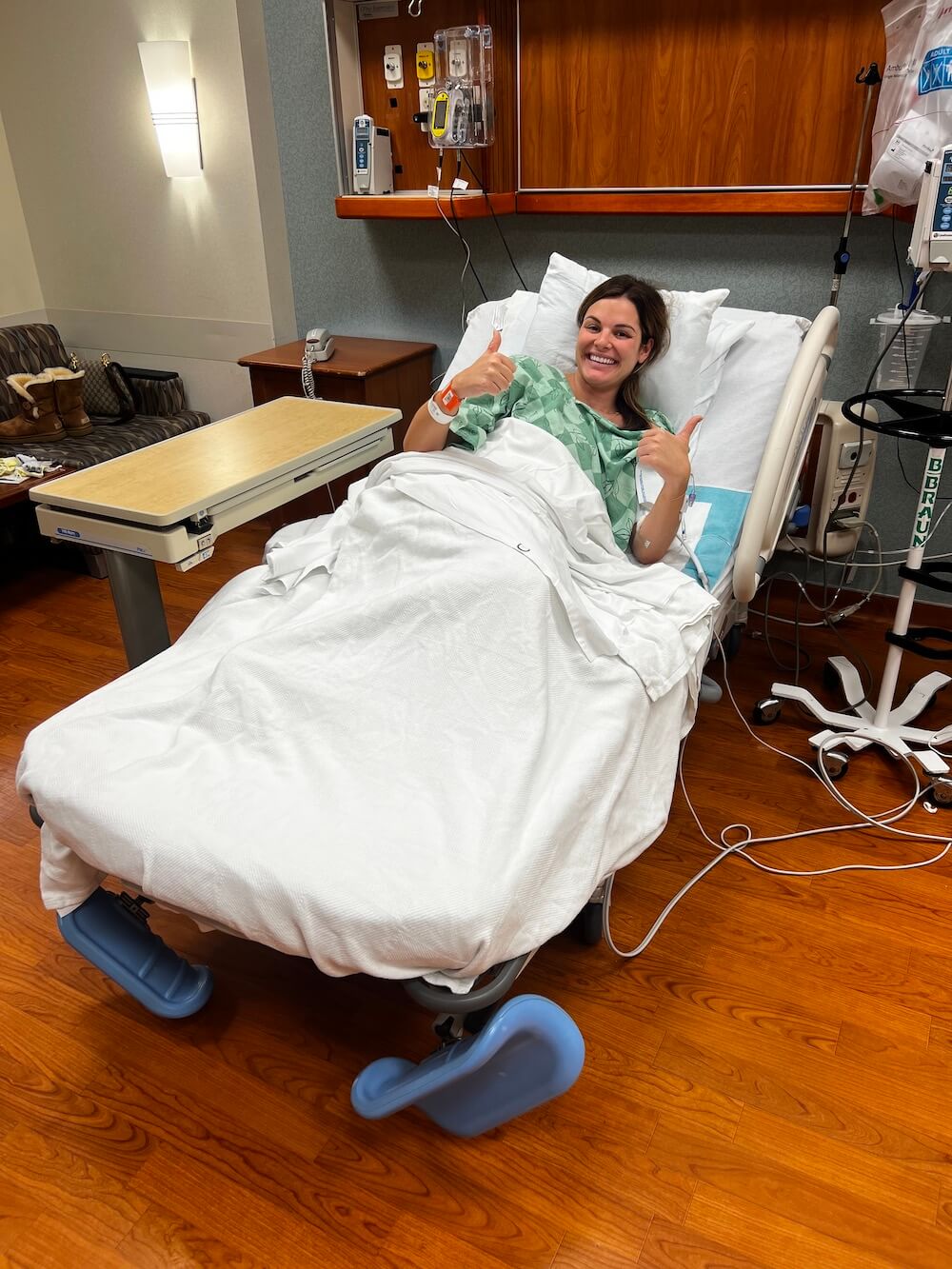woman in hospital bed giving thumbs up