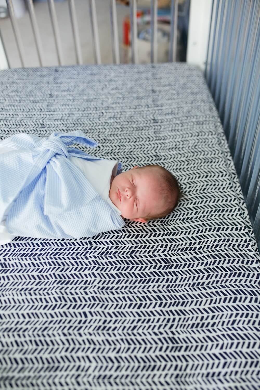 newborn baby boy laying in his crib sleeping