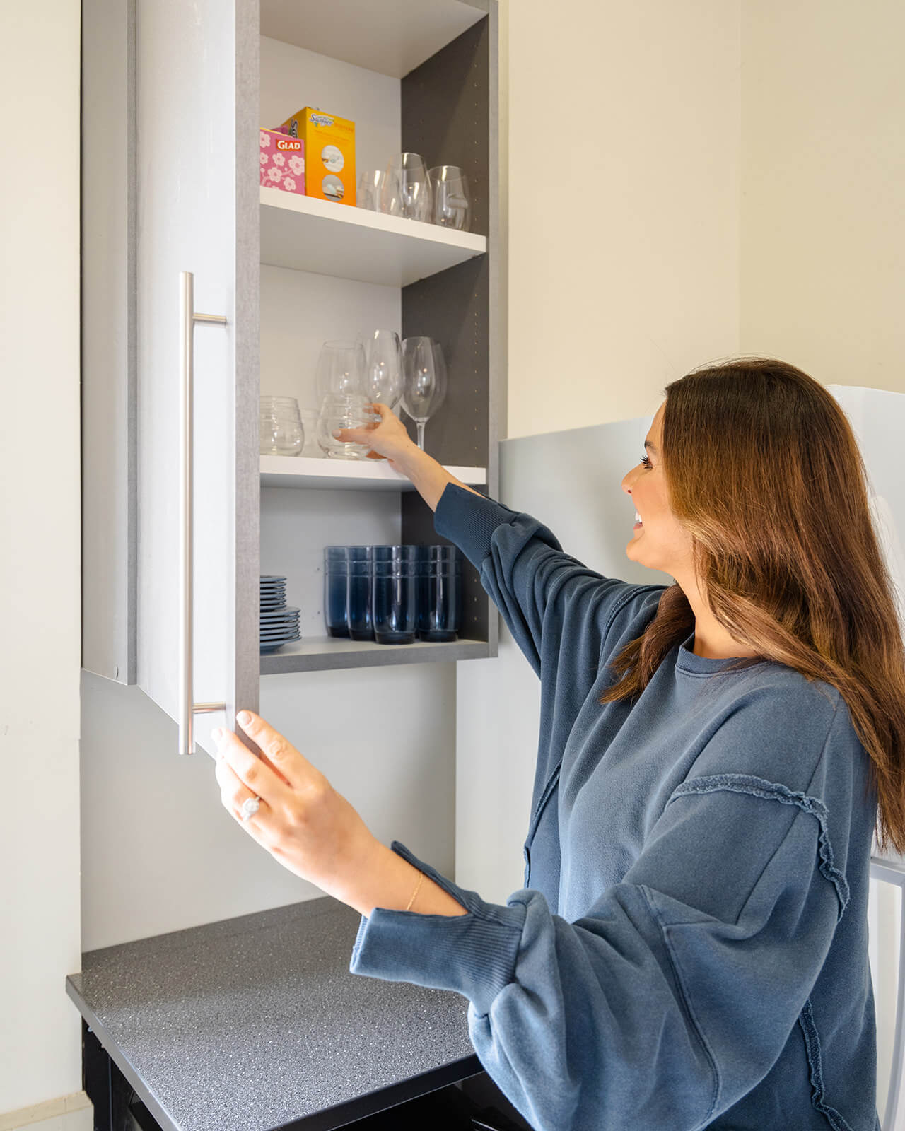 woman putting glasses on shelf