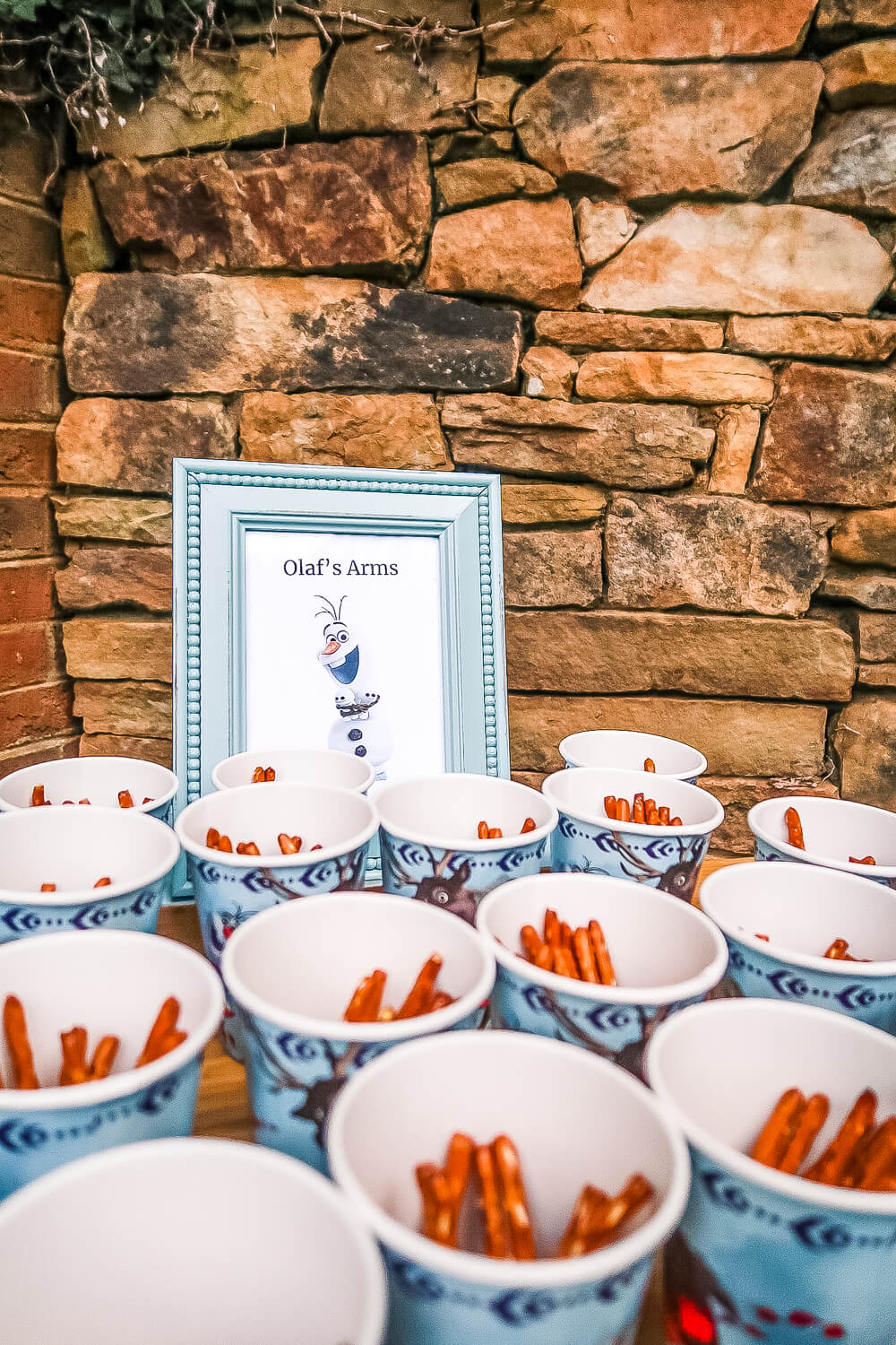 cups of olaf's arms with pretzel rods in them