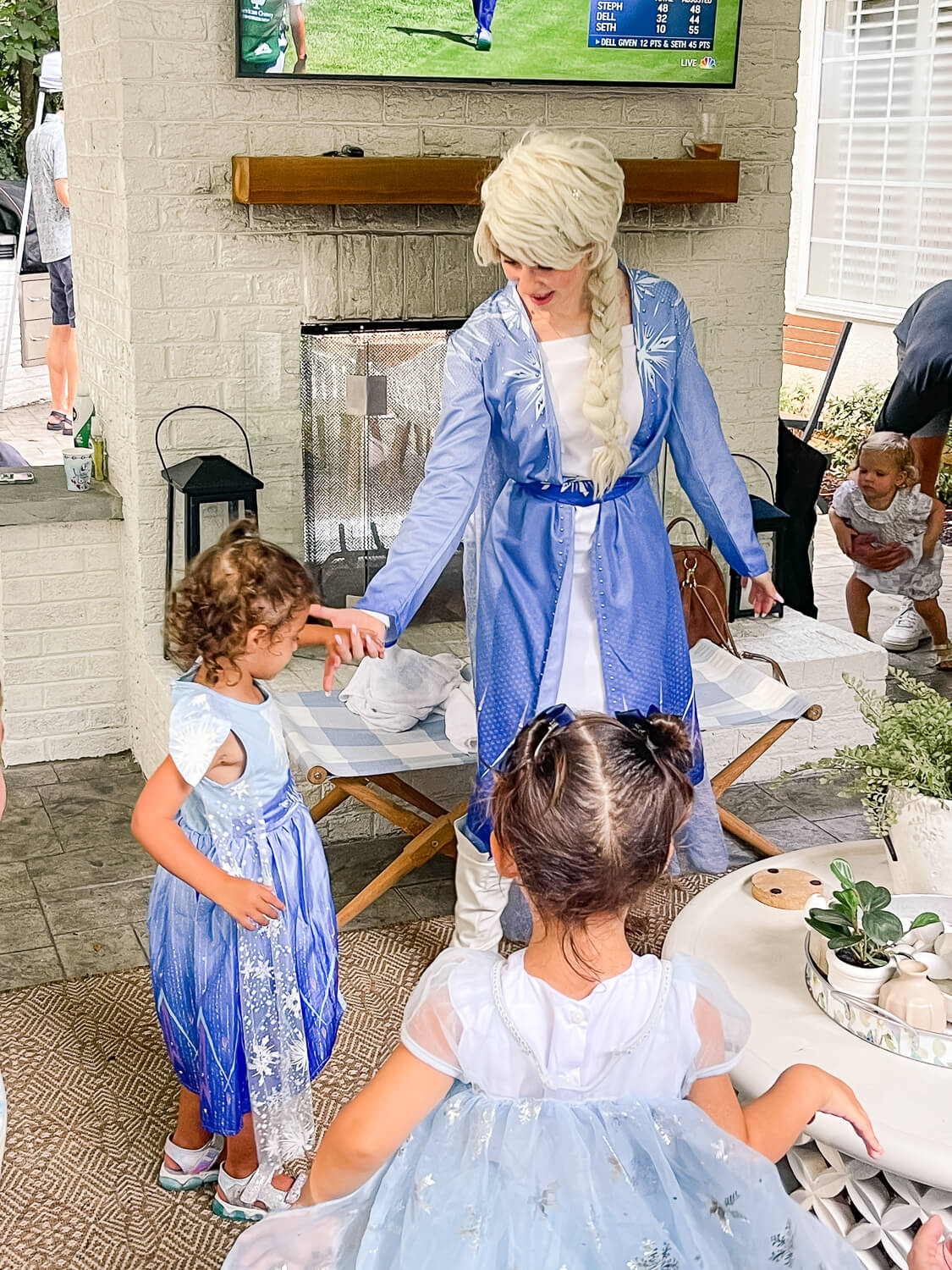 woman dressed like Elsa holding little girls hand