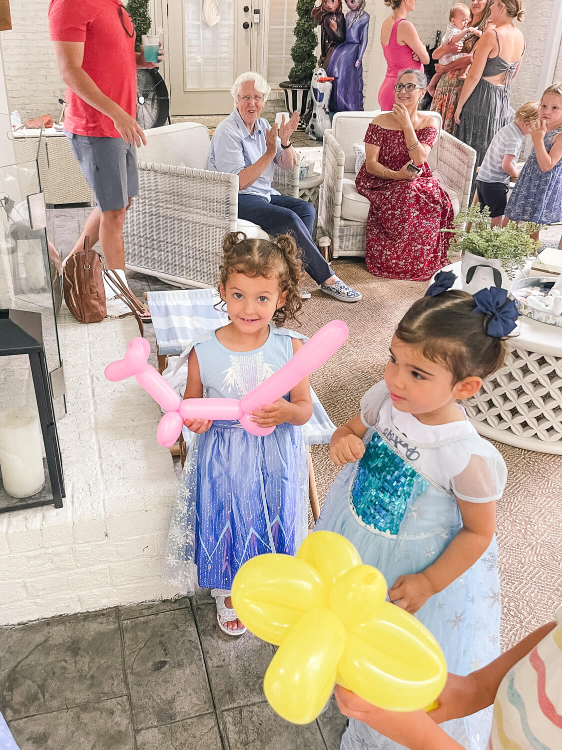 2 little girls holding balloon animals