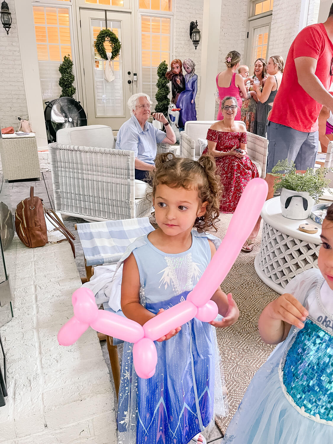 2 little girls holding balloon animals