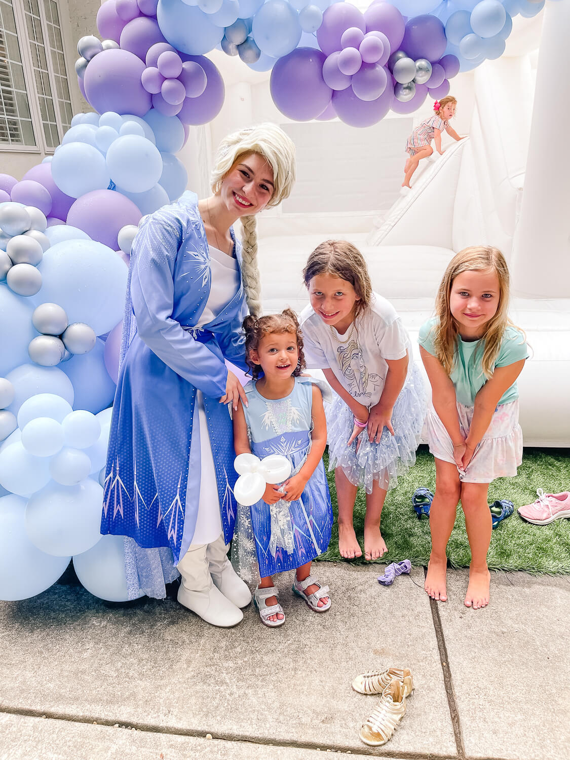 little kids standing next to woman dressed like Elsa