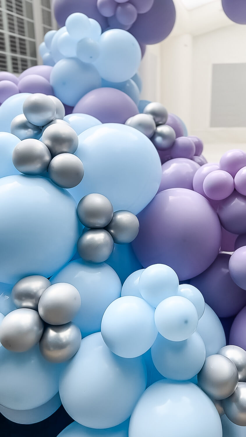 closeup of balloon arch with blue and purple balloons in different sizes